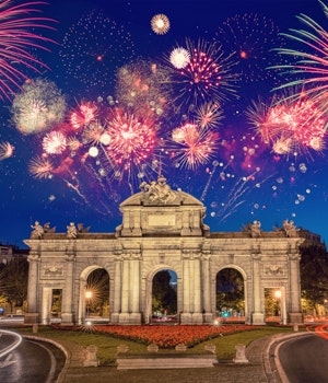 Fireworks going off in the sky above the Alcalá gate in Madrid, Spain